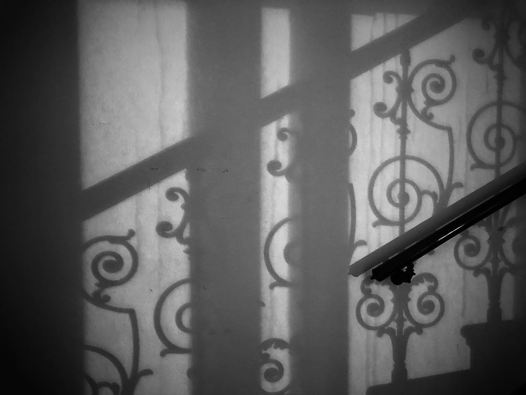 Banister alongside a staircase shadow